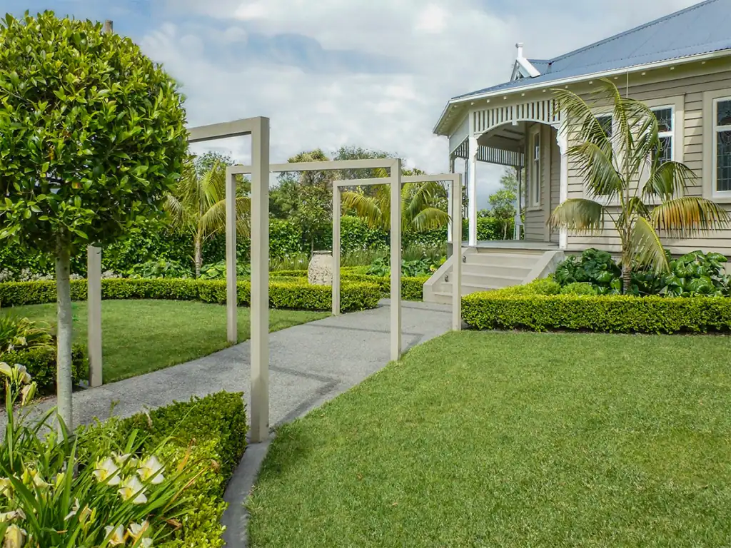 Mt Eden formal garden with timber arbors, large circular lawn and feature pot.