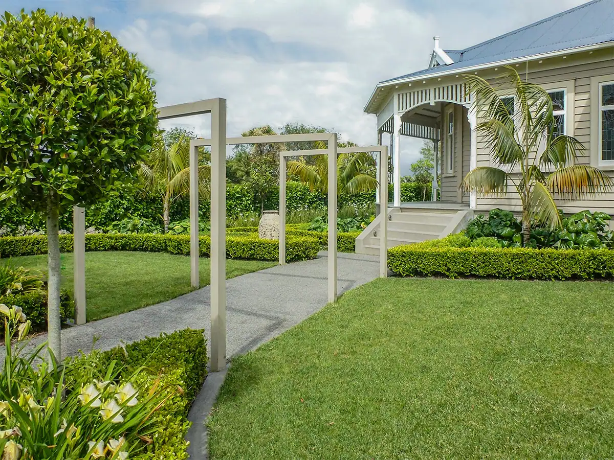 Mt Eden formal garden with timber arbors, large circular lawn and feature pot.