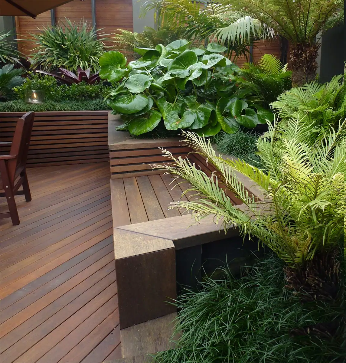 Built-in timber bench seat nestled into a raised garden in Birkenhead.