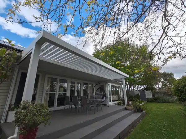 Contemporary pergola creating covered outdoor living and shade. Modern pergola structure attached to house creating covered outdoor living and shade.