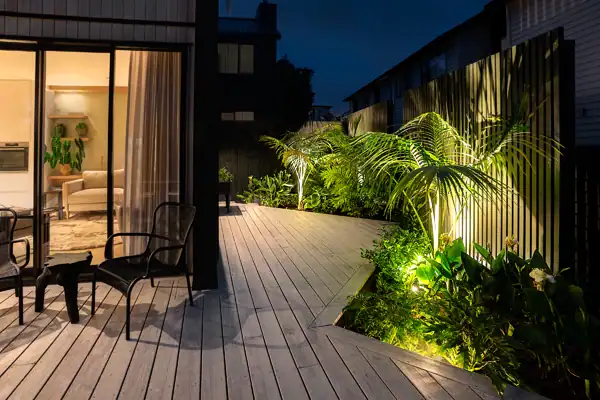 Modern Town House Garden at Night Night view of modern town house deck garden with tropical planting and feature lighting.