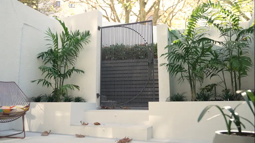 Small Inner-City Courtyard After Renovation Finished small inner-city courtyard with tropical planting, modern tiling and refreshed raised planters after landscape renovation.